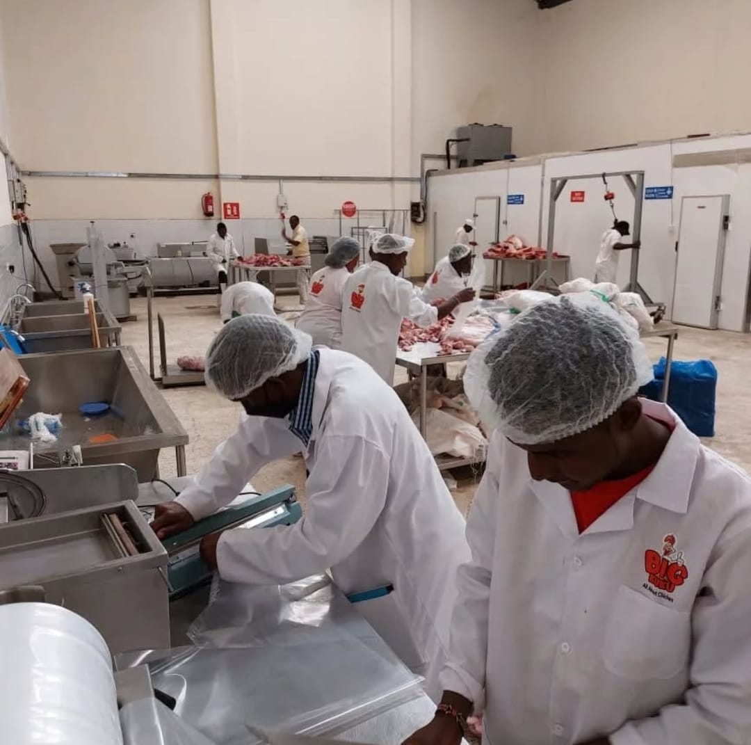 Staff in whites and hairnets working on the Kamundia Butchery processing floor in Nairobi